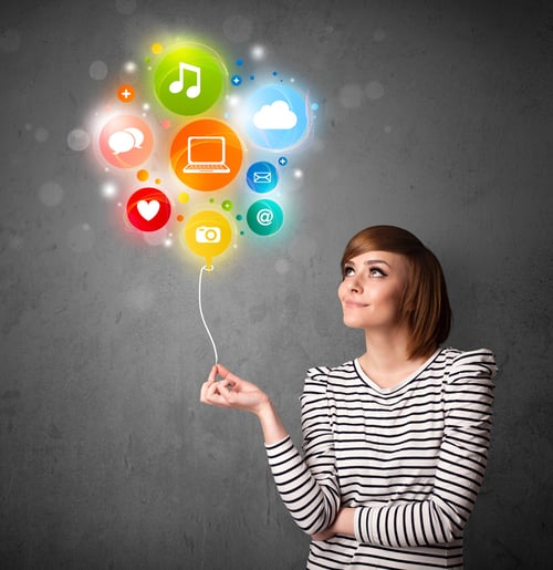 Pretty young woman holding colorful social media icons balloon